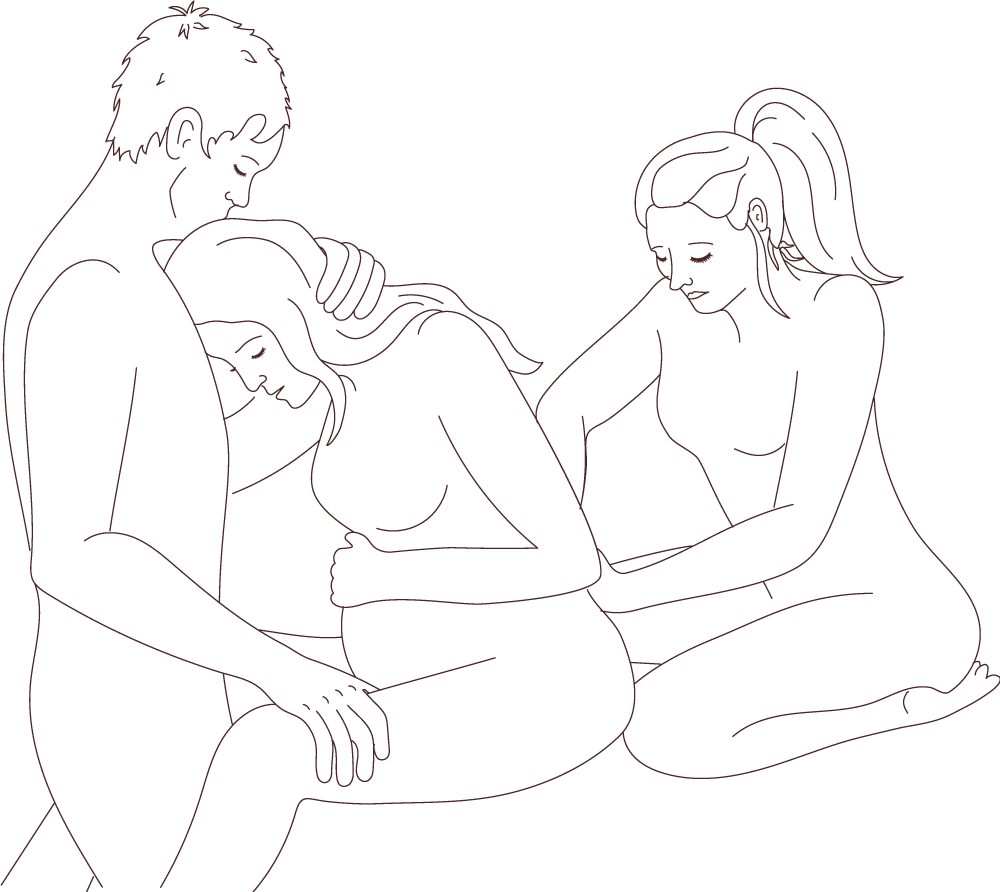 Femme enceinte en travail, pendant son accouchement. Elle est assise, la tête penchée vers l'avant, le front sur le torse de son partenaire qui lui tient la nuque. Une femme, sa doula, est derrière elle et lui fait des points de pression dans le dos.